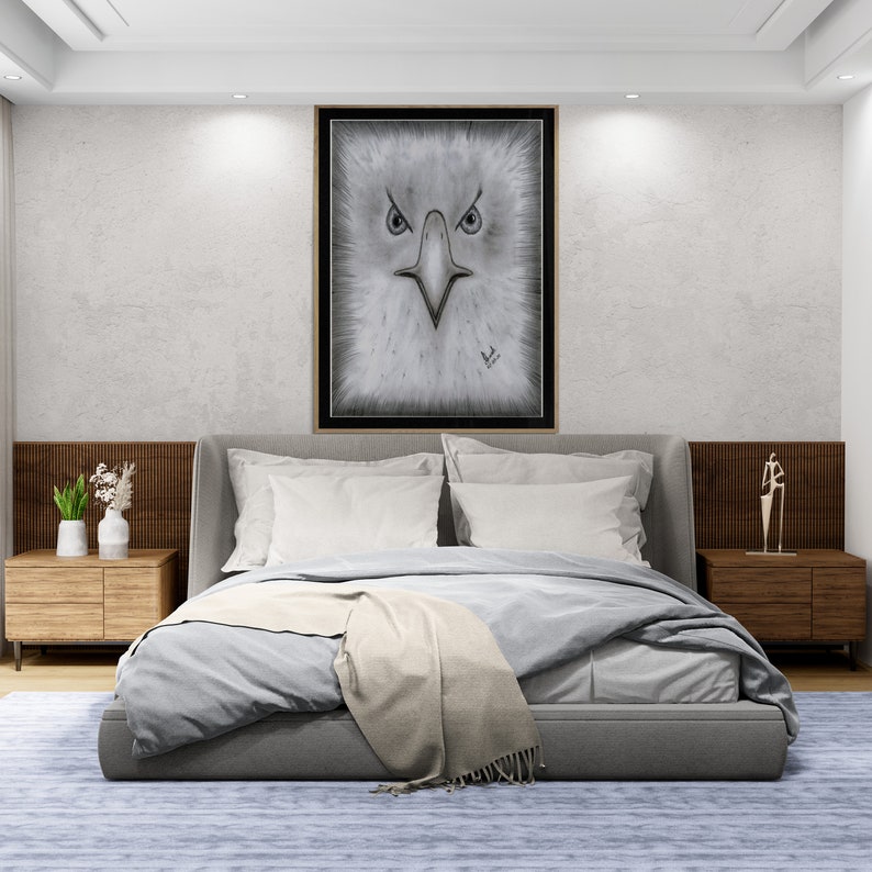K&ouml;nnte beinhalten: Ein graues Schlafzimmer mit einem Bett, zwei Nachttischen und einem gerahmten Schwarzwei&szlig;bild eines Adlergesichts &uuml;ber dem Bett.