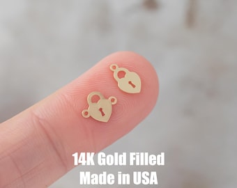 Op de afbeelding: Twee hartvormige slootbedels van goudvulling met een sleutelgatdetail. 14K Gold Filled Made in USA.