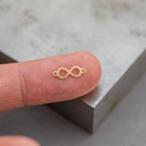 Könnte beinhalten: Ein goldener Unendlichkeits-Anhänger, perfekt für die Schmuckherstellung oder um Ihren Bastelarbeiten einen Hauch von Eleganz zu verleihen.