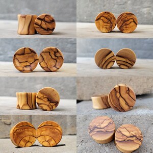 May include: A set of 10 wooden ear gauges in various sizes and patterns. The gauges are made of olive wood and have a natural, rustic finish.