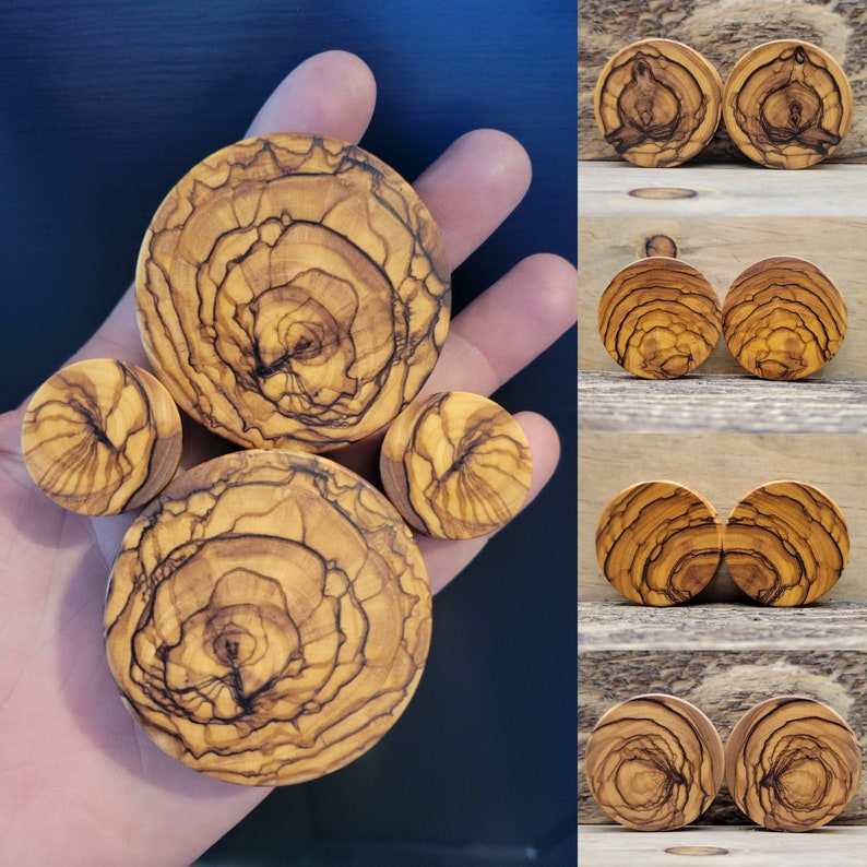 May include: A set of six wooden ear gauges in various sizes, featuring a natural wood grain pattern with dark brown streaks. The gauges are round and have a smooth, polished finish.
