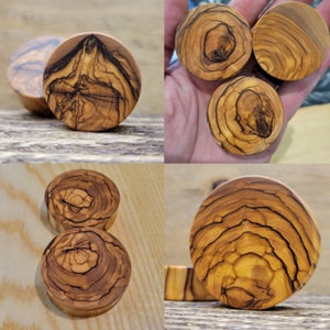 May include: A set of six wooden ear gauges with a natural wood grain pattern. The gauges are round and have a smooth finish.