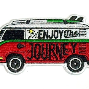 May include: Embroidered patch featuring a red, white, and green van with the words "ENJOY THE JOURNEY." The van has a surfboard on top and black wheels. The patch is a travel-themed accessory.
