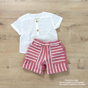 May include: White linen short-sleeved shirt with a single button closure and red and white striped linen shorts.
