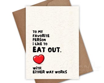 May include: A greeting card with the text "TO MY FAVORITE PERSON I LIKE TO EAT OUT. WITH. EITHER WAY WORKS" in black font. A red heart graphic is below "EAT OUT." The card is on a brown envelope.