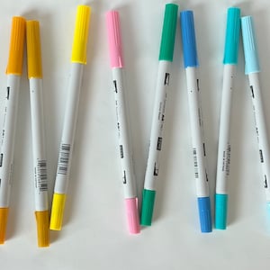 May include: A set of ten markers with white barrels and colored tips. The colors are red, yellow, yellow, yellow, pink, green, blue, blue, blue, and brown.