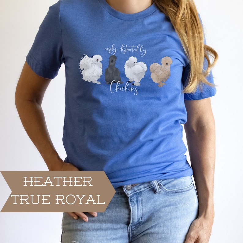 May include: A blue t-shirt with the text "easily distracted by chickens" and a graphic of four chickens. The shirt is a heather true royal color.
