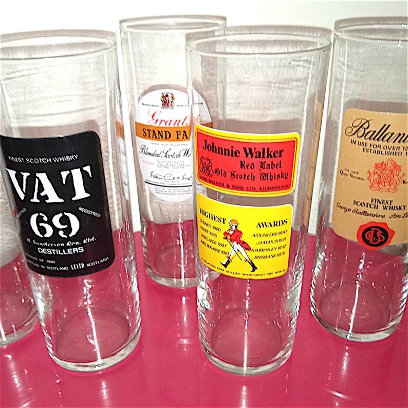 May include: Five clear glass tumblers with different Scotch whisky labels. The labels feature the brands Vat 69, Grant's Stand Fast, Johnnie Walker Red Label, and Ballantine's Finest Scotch Whisky.