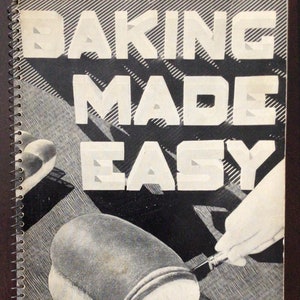 Peut inclure: Un livre de cuisine vintage avec une photo en noir et blanc d'une miche de pain en train d'être tranchée sur une planche à découper. Le titre du livre est "Baking Made Easy".
