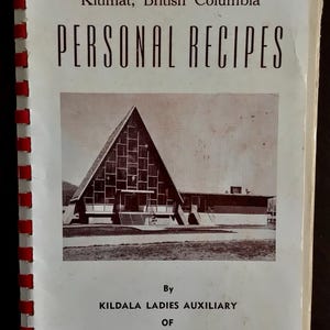 Peut inclure: Un livre de cuisine à reliure spirale blanche intitulé Personal Recipes de Kitimat, Colombie-Britannique. La couverture présente une photographie en noir et blanc d'une église triangulaire et le texte identifiant la Kildala Ladies Auxiliary.