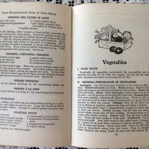 May include: A vintage cookbook open to a page titled "Vegetables" with a black and white illustration of a basket of vegetables. The text on the page discusses the nutritional value of vegetables and provides instructions for preparing them.