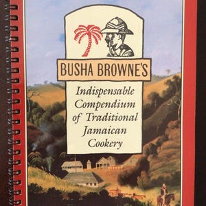 May include: A red spiral bound cookbook with a colourful illustration of a Jamaican landscape. The title is "Busha Browne's Indispensable Compendium of Traditional Jamaican Cookery".
