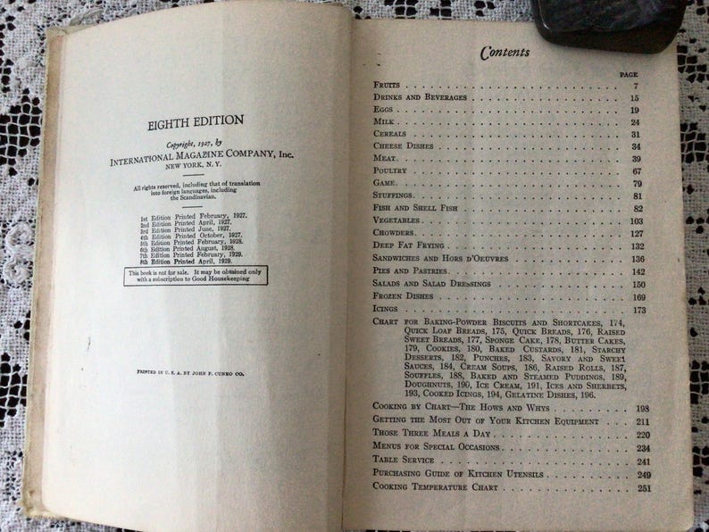 May include: A vintage cookbook titled "Eighth Edition" by International Magazine Company, Inc. The book lists various recipes and cooking techniques, including baking, desserts, and frozen dishes.