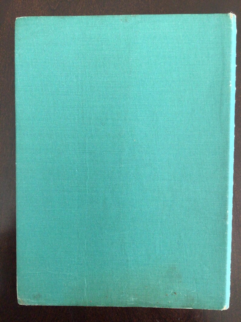 Puede incluir: Un libro de tapa dura rectangular con una cubierta de tela lisa de color verde azulado. El libro presenta una textura simple y uniforme en toda la superficie frontal, sin texto, ilustraciones ni marcas visibles en el exterior de la encuadernaci&oacute;n.