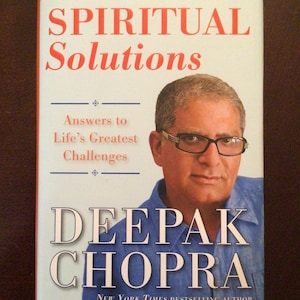 May include: A book cover with the title "SPIRITUAL Solutions" and the author's name, Deepak Chopra. The cover features a portrait of the author and the subtitle "Answers to Life's Greatest Challenges". The top banner reads "RELATIONSHIPS + SUCCESS + HEALTH + PERSONAL GROWTH".