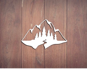 May include: White mountain and forest silhouette design. The image features a stylized depiction of a mountain range with several pine trees in the foreground. The design is set against a brown wooden background.