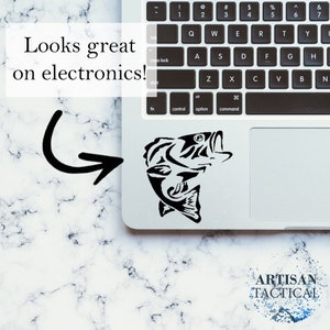 Puede incluir: Una calcoman&iacute;a de pez negro y blanco en forma de bajo en una computadora port&aacute;til plateada. La calcoman&iacute;a est&aacute; en el panel t&aacute;ctil de la computadora port&aacute;til. El texto "ARTISAN TACTICAL" es visible debajo de la computadora port&aacute;til.