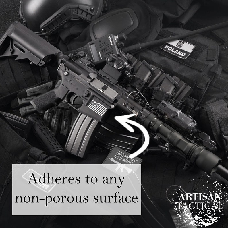 Puede incluir: Una linterna t&aacute;ctica negra con un agarre texturizado y un anillo de metal. La linterna est&aacute; unida a un rifle negro con una pegatina de bandera estadounidense en blanco y negro. El texto "SPECNA ARMS" es visible en un parche negro.