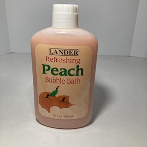 May include: A peach-colored plastic bottle of Lander Refreshing Peach Bubble Bath. The label features the brand name, product name, and a graphic of peaches. The bottle contains 32 fl oz (950 ml) of bubble bath.