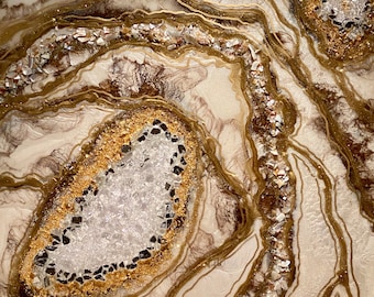 Puede incluir: Pintura abstracta con fondo blanco y detalles dorados y marrones. La pintura presenta una gran forma blanca similar a una geoda en el centro, rodeada de formas más pequeñas, doradas y marrones.
