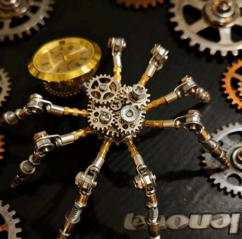 Pu&ograve; includere: Una scultura meccanica a forma di ragno in stile steampunk realizzata con ingranaggi, parti di orologi e aste metalliche. Il ragno ha otto zampe articolate e un quadrante come corpo. La scultura &egrave; ambientata su uno sfondo scuro con ingranaggi aggiuntivi.