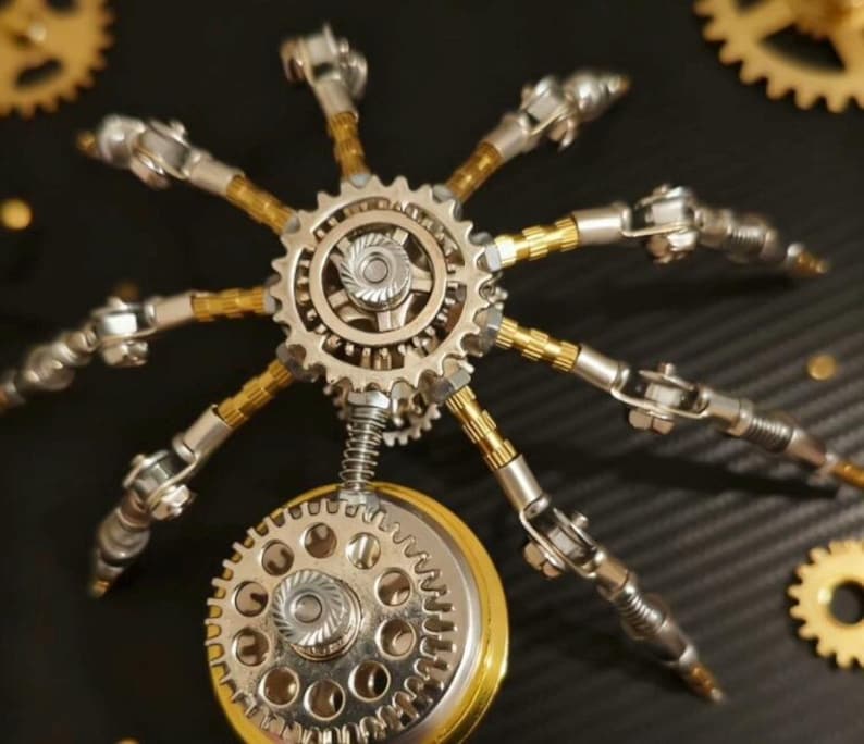 Pu&ograve; includere: Una scultura in metallo in stile steampunk raffigurante un ragno meccanico. La scultura presenta ingranaggi, molle e zampe articolate con toni argento e oro. Il ragno &egrave; ambientato su uno sfondo scuro con ingranaggi aggiuntivi.