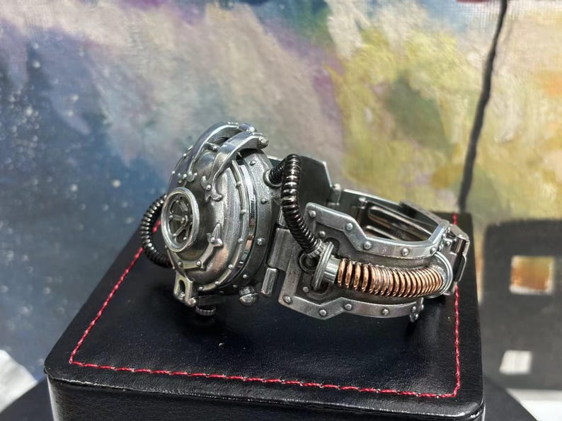 May include: A silver steampunk-style wristwatch with a round face and intricate gears. The watch has a copper-colored band with a textured surface.