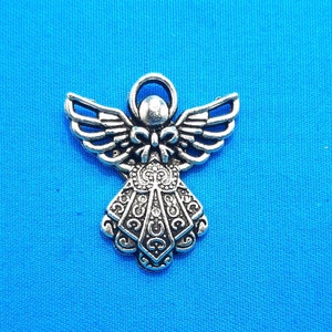 May include: A silver angel charm with intricate details and a halo. The angel is standing with its wings spread out.