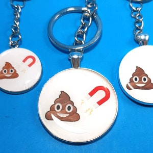 May include: Three silver keychains with round, white, and silver charms. Each charm features a brown poop emoji with a smiling face. One charm also has a red horseshoe magnet with lightning bolts.