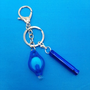 May include: A silver keychain with a blue whistle and a blue light-up charm. The keychain has a silver ring and a silver chain.