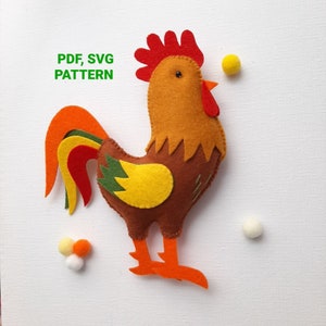 Puede incluir: Un patrón de gallo de fieltro para coser. El patrón incluye archivos PDF y SVG. El gallo es marrón, naranja, amarillo, rojo y verde.