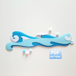 Może przedstawiać: Niebieska falująca fala oceanu z białych filcowych chmur. Fala jest wycięta i gotowa do szycia. Obraz zawiera również tekst "PDF PATTERN".