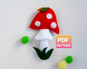 May include: A felt mushroom craft pattern, with a red cap with white dots, a white stem, and green leaves. The pattern is available as a PDF download.  PDF PATTERN text is visible in the image.