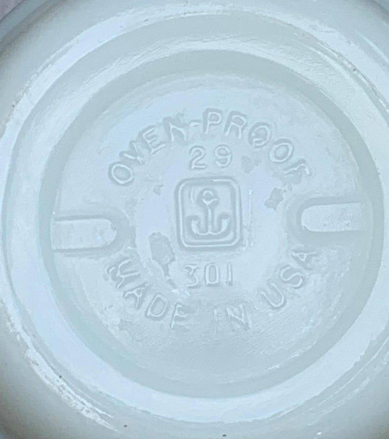 May include: White ceramic bowl with a circular inscription that reads "Oven-Proof 29 Made in USA" with an anchor symbol in the center.