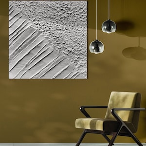 Peut inclure: Une grande œuvre d'art murale abstraite blanche texturée avec des lignes diagonales et une surface rugueuse. Deux lampes suspendues en verre foncé sont suspendues au plafond. Un fauteuil de style moderne du milieu du siècle avec un coussin vert et un cadre en bois foncé est au premier plan.