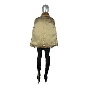 May include: A brown fur coat with a gold lining. The coat is shown on a mannequin from the back.