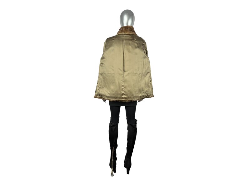 May include: A brown fur coat with a gold lining. The coat is shown on a mannequin from the back.