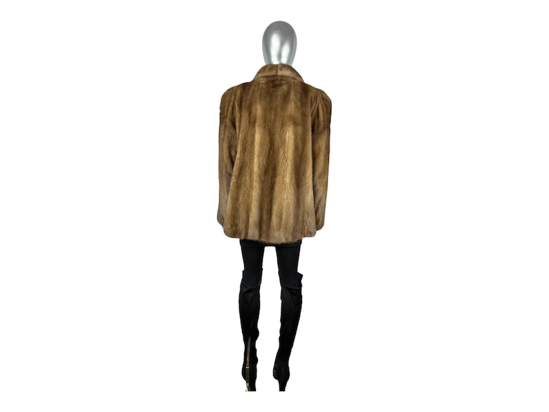 May include: A brown fur coat with a stand-up collar. The coat is worn on a mannequin.