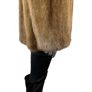 May include: A brown fur coat with a long sleeve and a soft, fluffy texture.