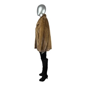 May include: A brown fur coat with a collar and long sleeves. The coat is worn on a mannequin.