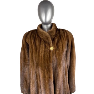 May include: A brown fur coat with a gold button closure.