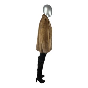 May include: A brown faux fur jacket with a collar and long sleeves. The jacket is worn on a mannequin.