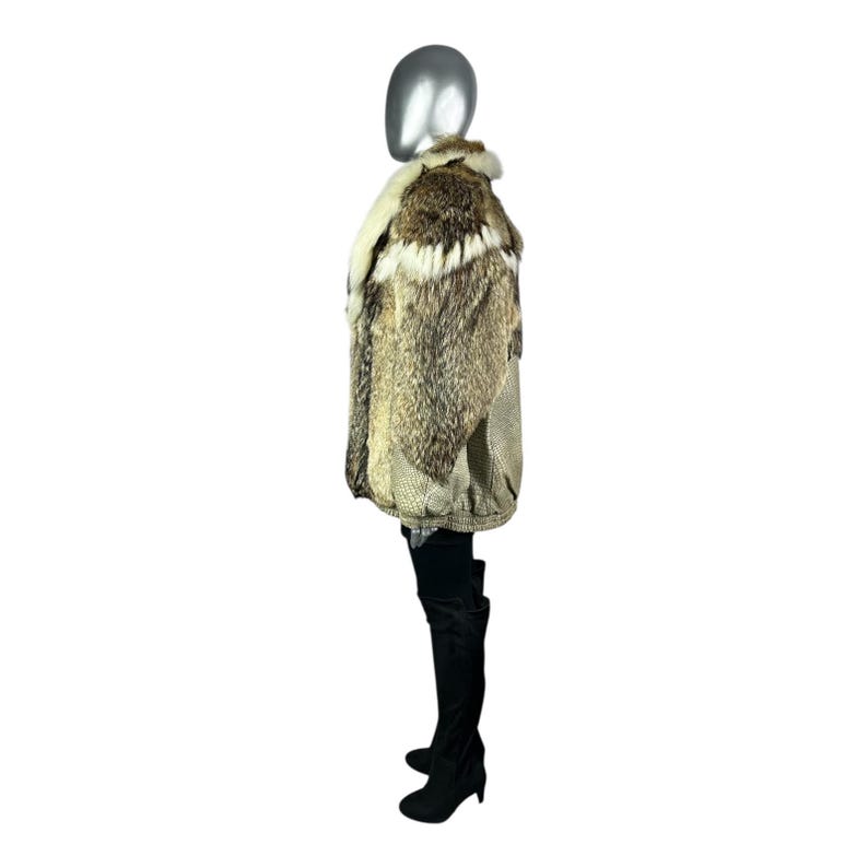 May include: A multi-toned fur coat with a cream-colored collar and a textured pattern. The coat is displayed on a mannequin, showcasing its design and texture. The coat is paired with black thigh-high boots.