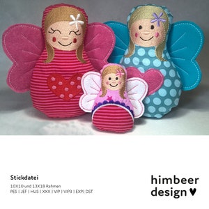 Könnte beinhalten: Drei gestickte Filz-Feenpuppen mit Flügeln. Die größte Puppe trägt ein rosa-weiß gestreiftes Kleid mit einem roten Herzen, die mittlere Puppe trägt ein rosa Kleid mit einem violetten Besatz und die kleinste Puppe trägt ein blau-weiß gepunktetes Kleid mit einem rosa Herzen.