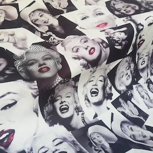May include: A white fabric with a black and white repeating pattern of Marilyn Monroe's face. The fabric has the word "Lovely" printed in the bottom right corner.