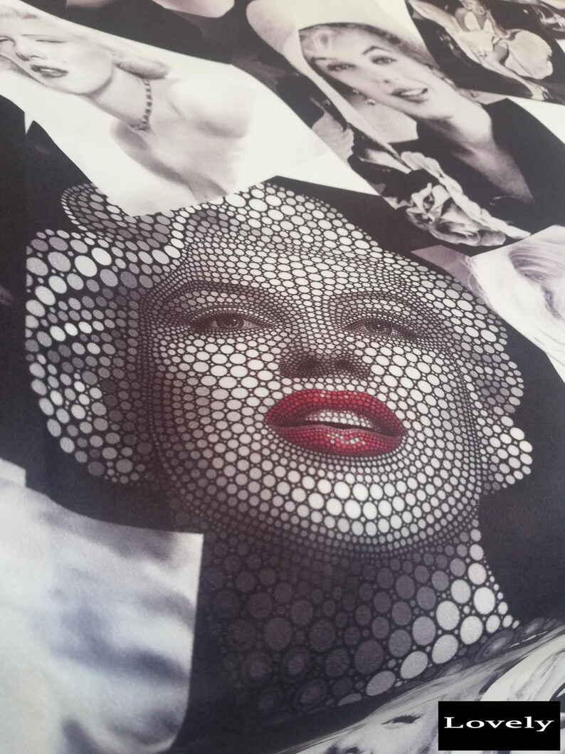 May include: A black and white fabric with a pattern of circles forming a face with red lips. The fabric has the word "Lovely" printed on the bottom right corner.