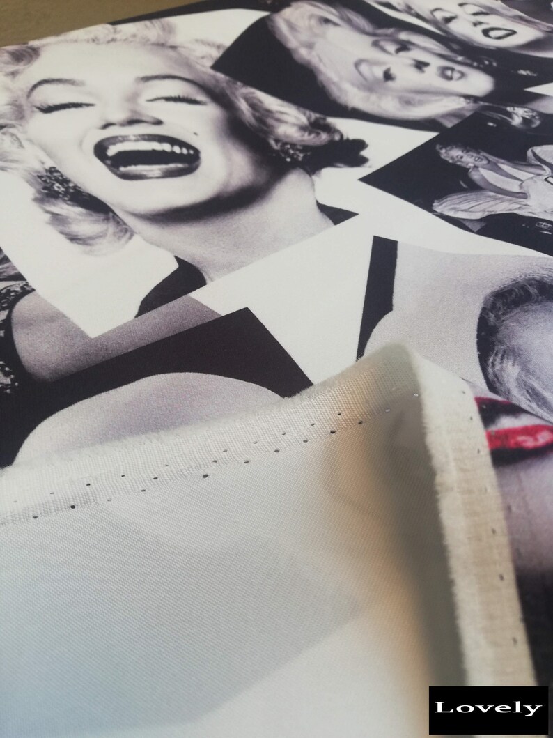 May include: A close-up of a white fabric with a black and white print of a woman's face. The fabric has a stitched edge and the word "Lovely" is printed in the bottom right corner.