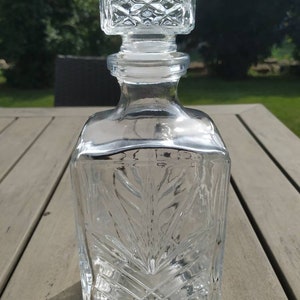 Square shaped whiskey decanter in molded glass. Made in Italy. Height. 24 cm. Width. 9.5cm. Base. 9 x 9 cm. New