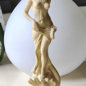 Sculpture of a Hindu deity/dancer, cobra trainer, standing on a bed of lotuses. Height 28 cm