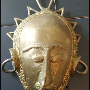 Máscara facial africana tribal decorativa. Ashanti de Ghana que data de los años 70. En latón. Altura. 19cm. estado de tuberculosis